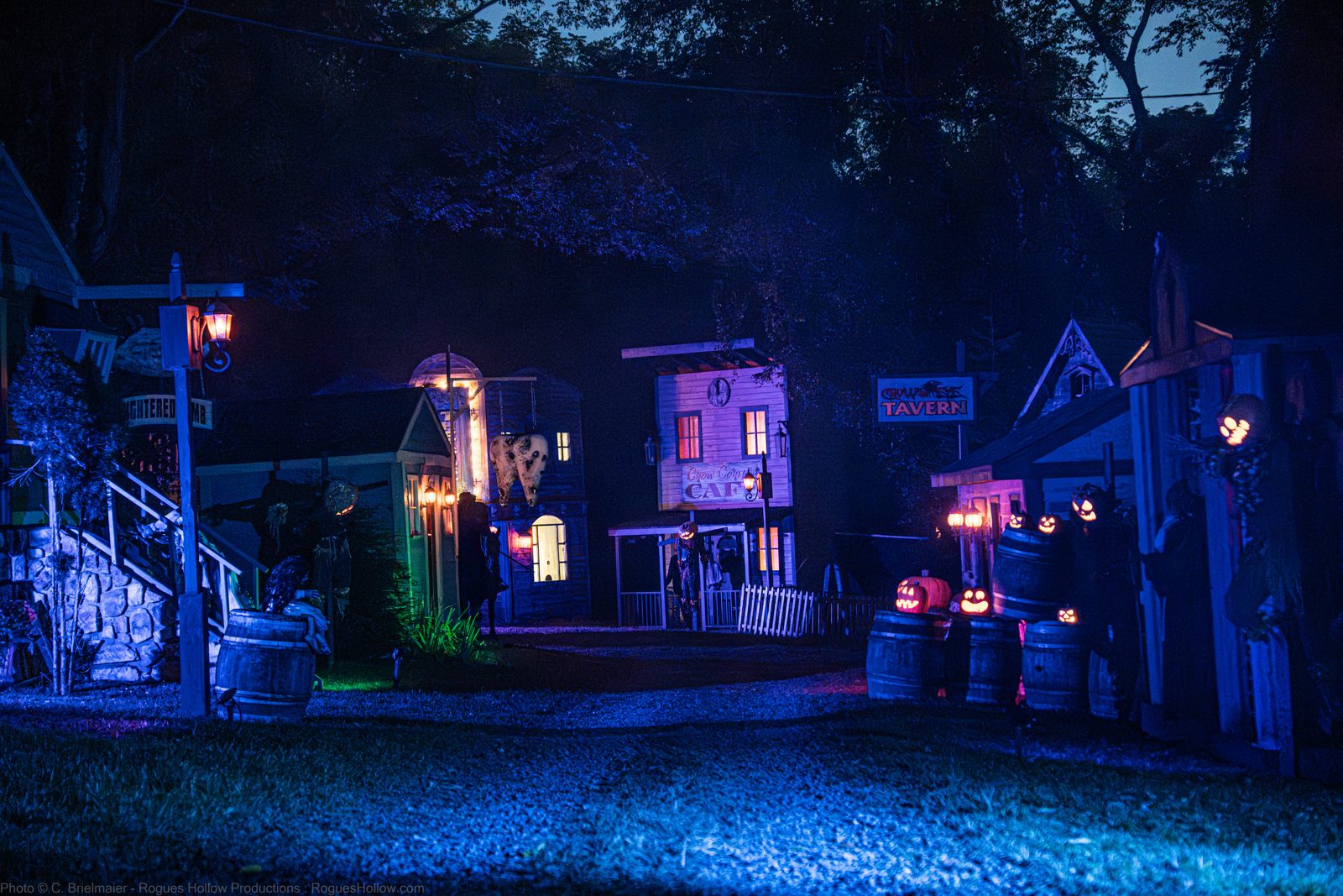 Lit haunted village scene along the hayride route at night at Headless Horseman, Ulster Park NY