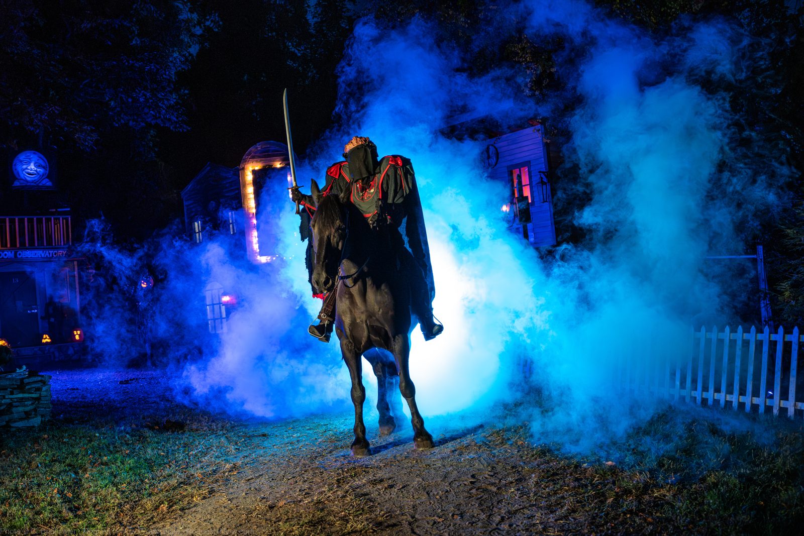 The Headless Horseman on horseback charging toward the hayride wagon through smoke